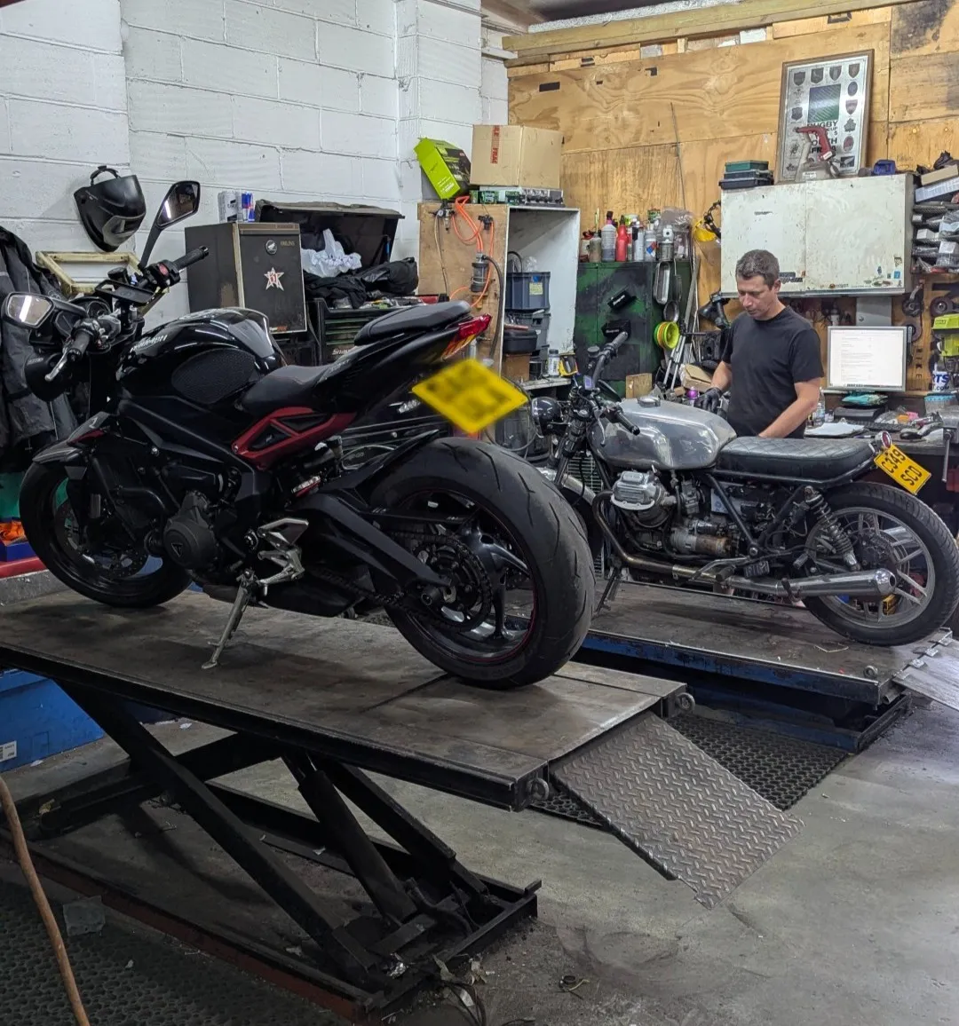 A technician working on motorcycles inside the Riverbank Motorcycles workshop in Bow, East London